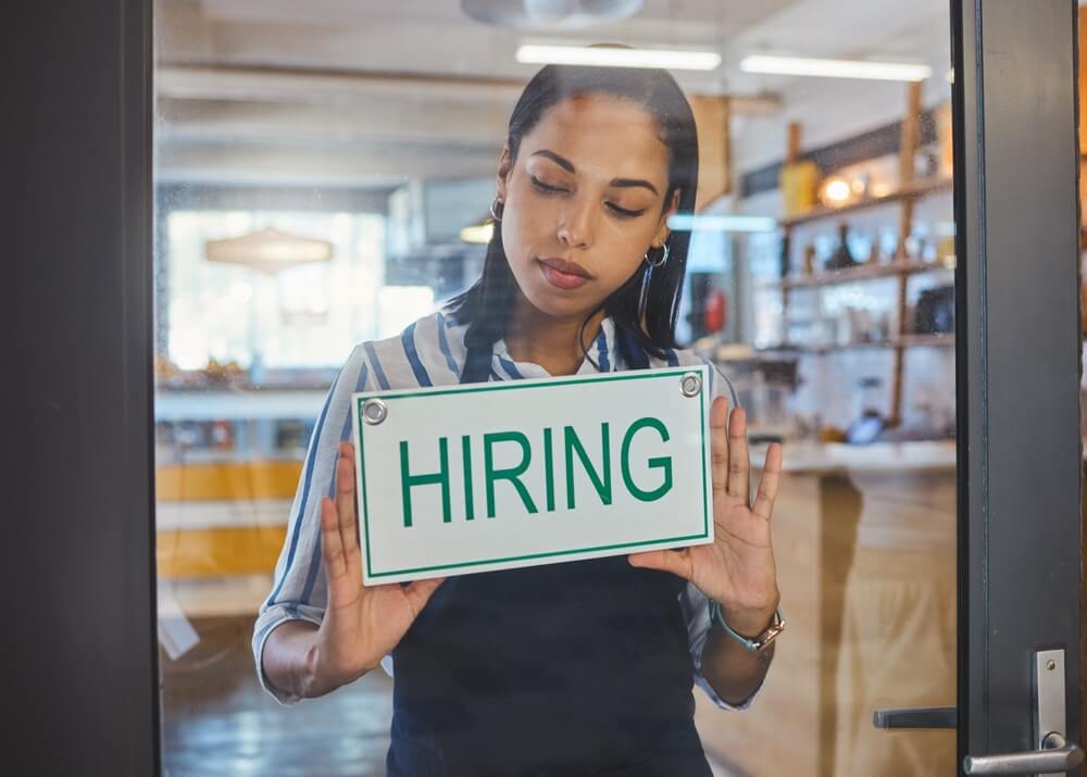 woman holding a hiring sign